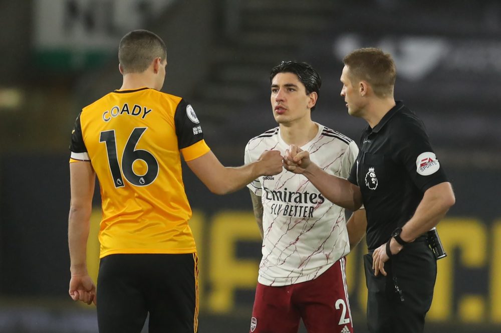 WOLVERHAMPTON, ENGLAND - FEBRUARY 02: Conor Coady of Wolverhampton Wanderers and Craig Pawson, the match referee interact following the coin toss as Hector Bellerin of Arsenal looks on during the Premier League match between Wolverhampton Wanderers and Arsenal at Molineux on February 02, 2021 in Wolverhampton, England. Sporting stadiums around the UK remain under strict restrictions due to the Coronavirus Pandemic as Government social distancing laws prohibit fans inside venues resulting in games being played behind closed doors. (Photo by Catherine Ivill/Getty Images)