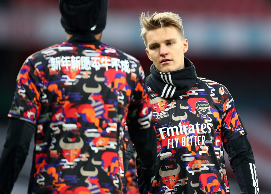 Arsenal's Norwegian midfielder Martin Odegaard (R) warms up for the English Premier League football match between Arsenal and Leeds United at the Emirates Stadium in London on February 14, 2021. (Photo by Julian Finney / POOL / AFP)