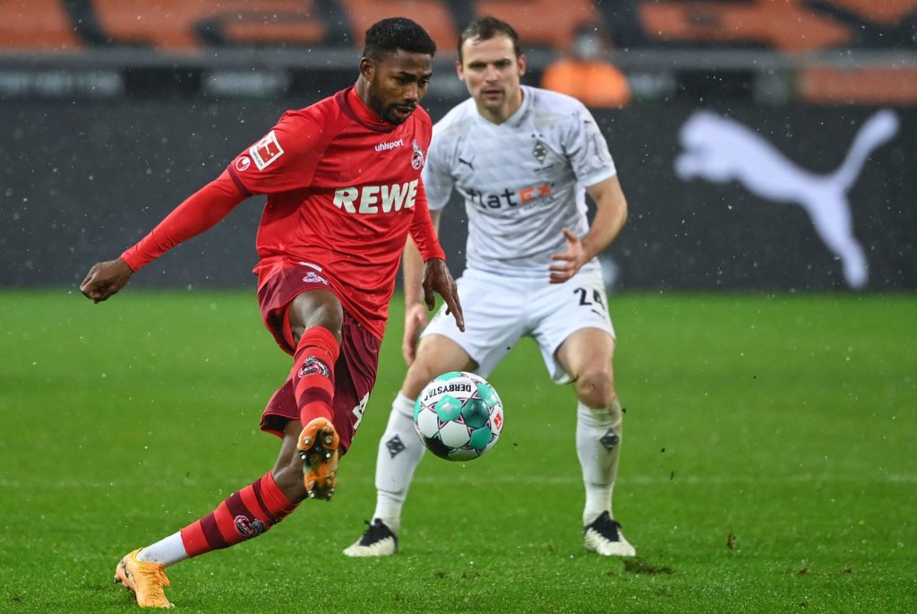 Cologne's Nigerian forward Emmanuel Dennis plays the ball in front of Moenchengladbach's German defender Tony Jantschke during the German first division Bundesliga football match between Borussia Moenchengladbach and 1 FC Cologne in Moenchengladbach, western Germany, on February 6, 2021. (Photo by INA FASSBENDER/AFP via Getty Images)