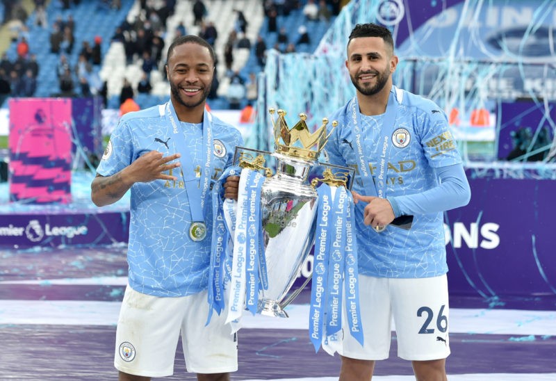 Raheem Sterling left and Riyad Mahrez pose with the trophy after the Premier League match at the Etihad Stadium, Manchester. Picture date: Sunday May 23, 2021.