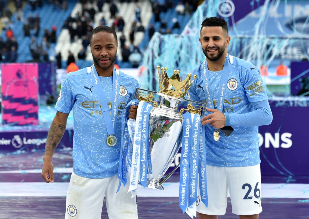 Raheem Sterling left and Riyad Mahrez pose with the trophy after the Premier League match at the Etihad Stadium, Manchester. Picture date: Sunday May 23, 2021.