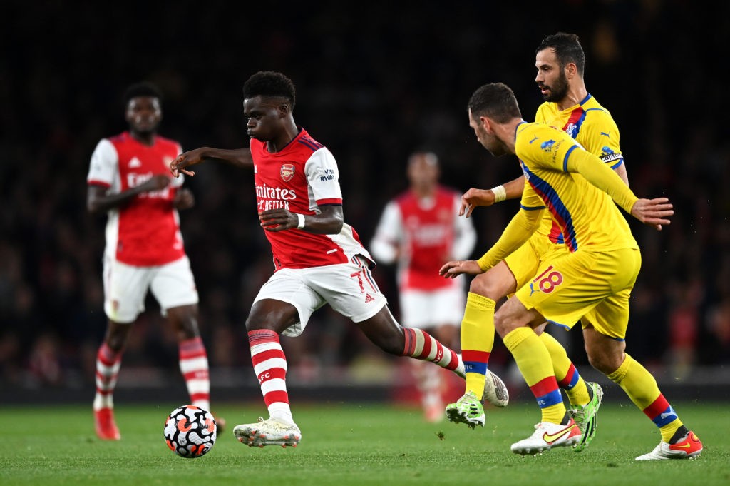 LONDON, ENGLAND - OCTOBER 18: Bukayo Saka of Arsenal breaks past Luka Milivojevic and James McArthur of Crystal Palace during the Premier League match between Arsenal and Crystal Palace at Emirates Stadium on October 18, 2021 in London, England. (Photo by Shaun Botterill/Getty Images)