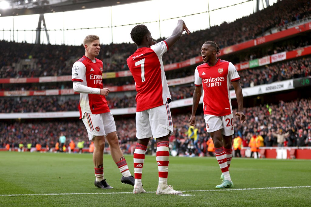 LONDON, ENGLAND - NOVEMBER 27: Bukayo Saka celebrates with teammates Emile Smith Rowe and Nuno Tavares of Arsenal after scoring their team's first goal during the Premier League match between Arsenal and Newcastle United at Emirates Stadium on November 27, 2021 in London, England. (Photo by Richard Heathcote/Getty Images)