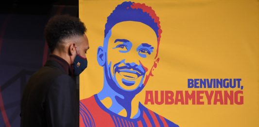 Barcelona's new player Gabonese forward Pierre-Emerick Aubameyang stands next to a poster reading "welcome Aubameyang" during a press conference for his official presentation, at the Camp Nou stadium in Barcelona on February 3, 2022. (Photo by LLUIS GENE / AFP) (Photo by LLUIS GENE/AFP via Getty Images)