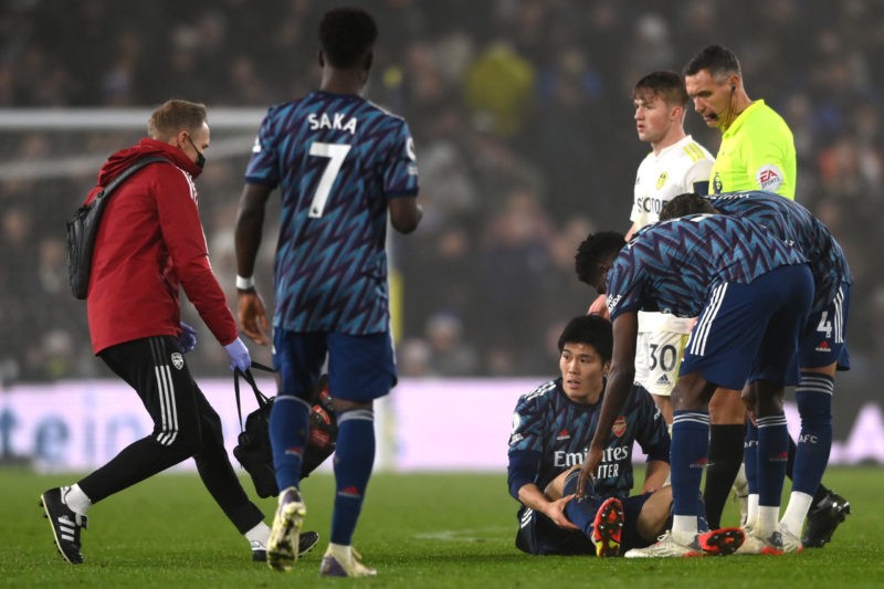LEEDS, ENGLAND - DECEMBER 18: Takehiro Tomiyasu of Arsenal goes down injured during the Premier League match between Leeds United  and  Arsenal at Elland Road on December 18, 2021 in Leeds, England. (Photo by Stu Forster/Getty Images)