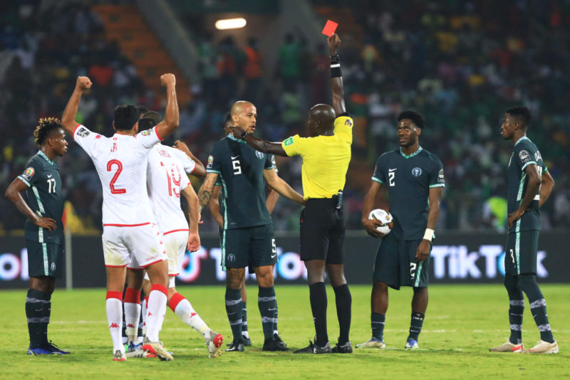 Senegalese referee Maguette N'Diaye (C) gives a red card to Nigeria's forward Alex Iwobi (unseen) during the Africa Cup of Nations (CAN) 2021 round of 16 football match between Nigeria and Tunisia at Stade Roumde Adjia in Garoua on January 23, 2022. (Photo by Daniel BELOUMOU OLOMO / AFP) (Photo by DANIEL BELOUMOU OLOMO/AFP via Getty Images)