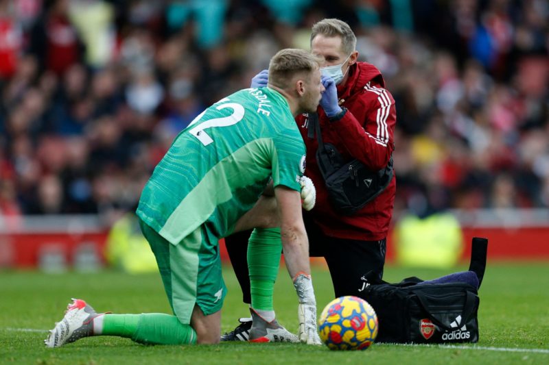 Arsenal's English goalkeeper Aaron Ramsdale receives medical attention during the English Premier League football match between Arsenal and Manchester City at the Emirates Stadium in London on January 1, 2022. - - RESTRICTED TO EDITORIAL USE. No use with unauthorized audio, video, data, fixture lists, club/league logos or 'live' services. Online in-match use limited to 120 images. An additional 40 images may be used in extra time. No video emulation. Social media in-match use limited to 120 images. An additional 40 images may be used in extra time. No use in betting publications, games or single club/league/player publications. (Photo by Ian KINGTON / IKIMAGES / AFP) / RESTRICTED TO EDITORIAL USE. No use with unauthorized audio, video, data, fixture lists, club/league logos or 'live' services. Online in-match use limited to 120 images. An additional 40 images may be used in extra time. No video emulation. Social media in-match use limited to 120 images. An additional 40 images may be used in extra time. No use in betting publications, games or single club/league/player publications. / RESTRICTED TO EDITORIAL USE. No use with unauthorized audio, video, data, fixture lists, club/league logos or 'live' services. Online in-match use limited to 120 images. An additional 40 images may be used in extra time. No video emulation. Social media in-match use limited to 120 images. An additional 40 images may be used in extra time. No use in betting publications, games or single club/league/player publications. (Photo by IAN KINGTON/IKIMAGES/AFP via Getty Images)