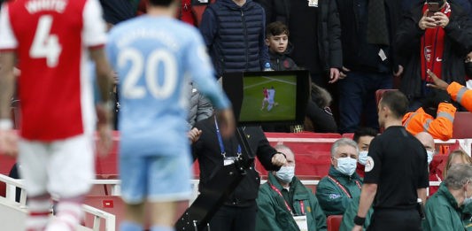 Referee Stuart Attwell (R) checks VAR and awards a penalty during the English Premier League football match between Arsenal and Manchester City at the Emirates Stadium in London on January 1, 2022. - - RESTRICTED TO EDITORIAL USE. No use with unauthorized audio, video, data, fixture lists, club/league logos or 'live' services. Online in-match use limited to 120 images. An additional 40 images may be used in extra time. No video emulation. Social media in-match use limited to 120 images. An additional 40 images may be used in extra time. No use in betting publications, games or single club/league/player publications. (Photo by Ian KINGTON / IKIMAGES / AFP) / RESTRICTED TO EDITORIAL USE. No use with unauthorized audio, video, data, fixture lists, club/league logos or 'live' services. Online in-match use limited to 120 images. An additional 40 images may be used in extra time. No video emulation. Social media in-match use limited to 120 images. An additional 40 images may be used in extra time. No use in betting publications, games or single club/league/player publications. / RESTRICTED TO EDITORIAL USE. No use with unauthorized audio, video, data, fixture lists, club/league logos or 'live' services. Online in-match use limited to 120 images. An additional 40 images may be used in extra time. No video emulation. Social media in-match use limited to 120 images. An additional 40 images may be used in extra time. No use in betting publications, games or single club/league/player publications. (Photo by IAN KINGTON/IKIMAGES/AFP via Getty Images)