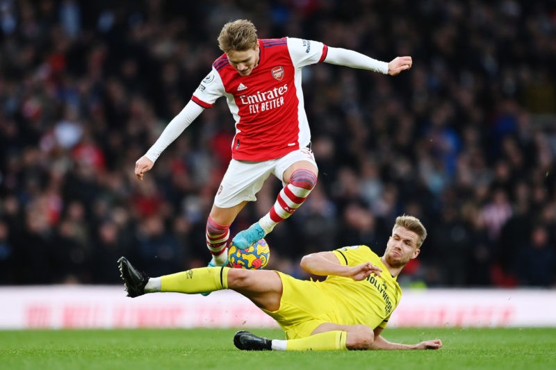 LONDON, ENGLAND - FEBRUARY 19: Martin Odegaard of Arsenal is challenged by Kristoffer Ajer of Brentford during the Premier League match between Arsenal and Brentford at Emirates Stadium on February 19, 2022 in London, England. (Photo by Shaun Botterill/Getty Images)