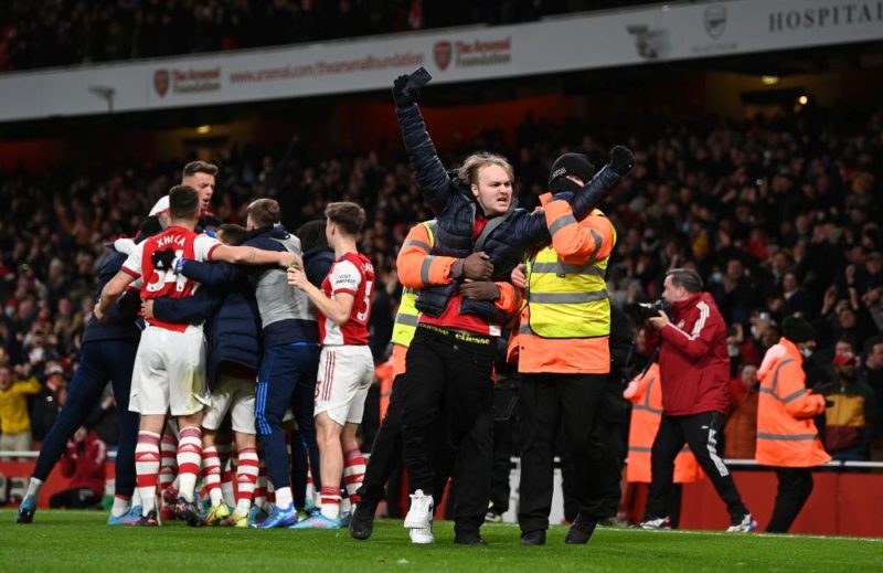 LONDON, ENGLAND - FEBRUARY 24: A pitch invader reacts as Alexandre Lacazette of Arsenal (hidden) celebrates their sides second goal with team mates during the Premier League match between Arsenal and Wolverhampton Wanderers at Emirates Stadium on February 24, 2022 in London, England. (Photo by Shaun Botterill/Getty Images)