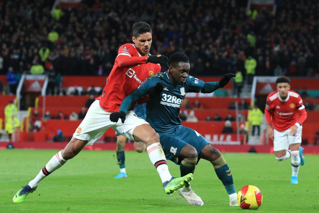Manchester United's French defender Raphael Varane (L) vies with Middlesbrough's English striker Folarin Balogun (R) during the English FA Cup fourth-round football match between Manchester United and Middlesbrough at Old Trafford in Manchester, north-west England, on February 4, 2022. (Photo by LINDSEY PARNABY / AFP via Getty Images)