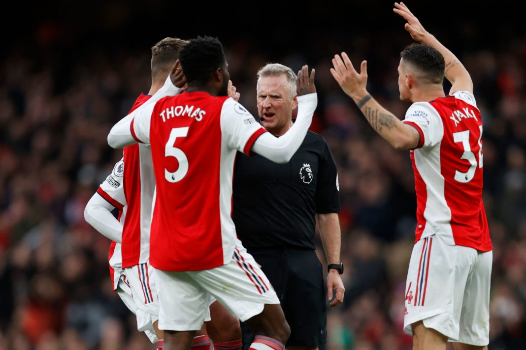 English referee Jonathan Moss (C) is surrounded by Arsenal players appealing for a handball decision during the English Premier League football match between Arsenal and Brentford at the Emirates Stadium in London on February 19, 2022. (Photo by IAN KINGTON/AFP via Getty Images)