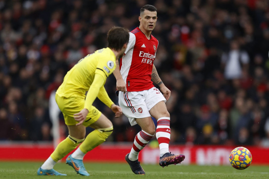 Arsenal's Swiss midfielder Granit Xhaka (R) passes the ball during the English Premier League football match between Arsenal and Brentford at the Emirates Stadium in London on February 19, 2022.(Photo by IAN KINGTON/AFP via Getty Images)