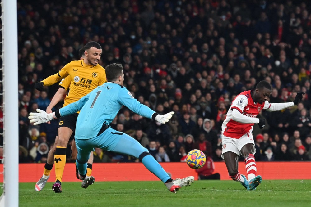 Arsenal's French-born Ivorian midfielder Nicolas Pepe (R) shoots to score their first goal during the English Premier League football match between Arsenal and Wolverhampton Wanderers at the Emirates Stadium in London on February 24, 2022. (Photo by GLYN KIRK/AFP via Getty Images)