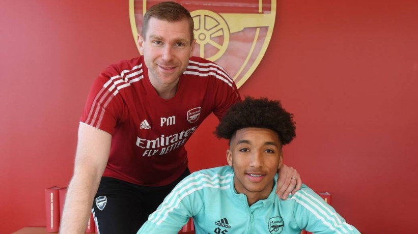 Bradley Ibrahim signing his professional contract with Per Mertesacker (Photo via Arsenal.com)