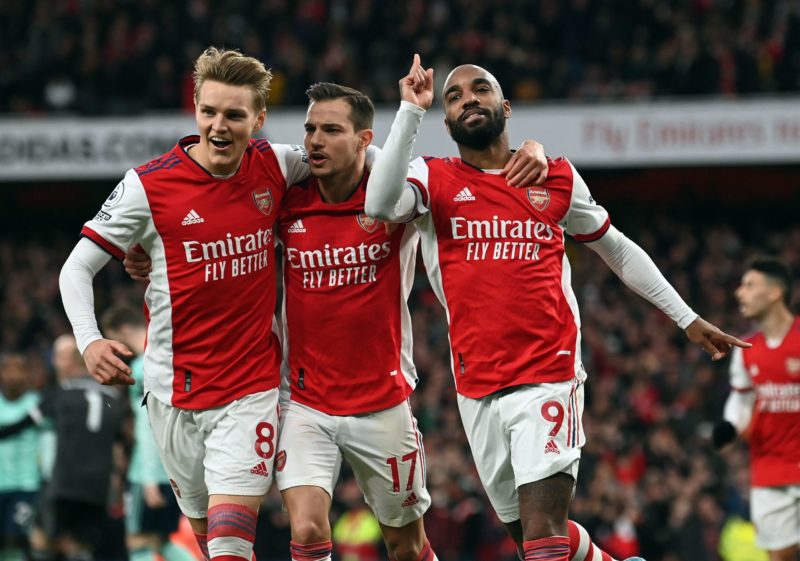 Arsenal's Norwegian midfielder Martin Odegaard (L) and Arsenal's German-born Portuguese defender Cedric Soares (C)congratulate goalscorer Arsenal's French striker Alexandre Lacazette during the English Premier League football match between Arsenal and Leicester City at the Emirates Stadium in London on March 13, 2022. (Photo by GLYN KIRK/AFP via Getty Images)