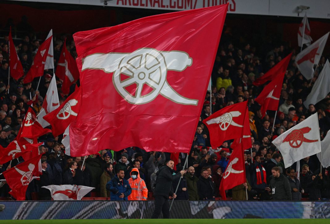 Arsenal fans wave flags ahead of the English Premier League football match between Arsenal and Liverpool at the Emirates Stadium in London on March 16, 2022. (Photo by ADRIAN DENNIS/AFP via Getty Images)