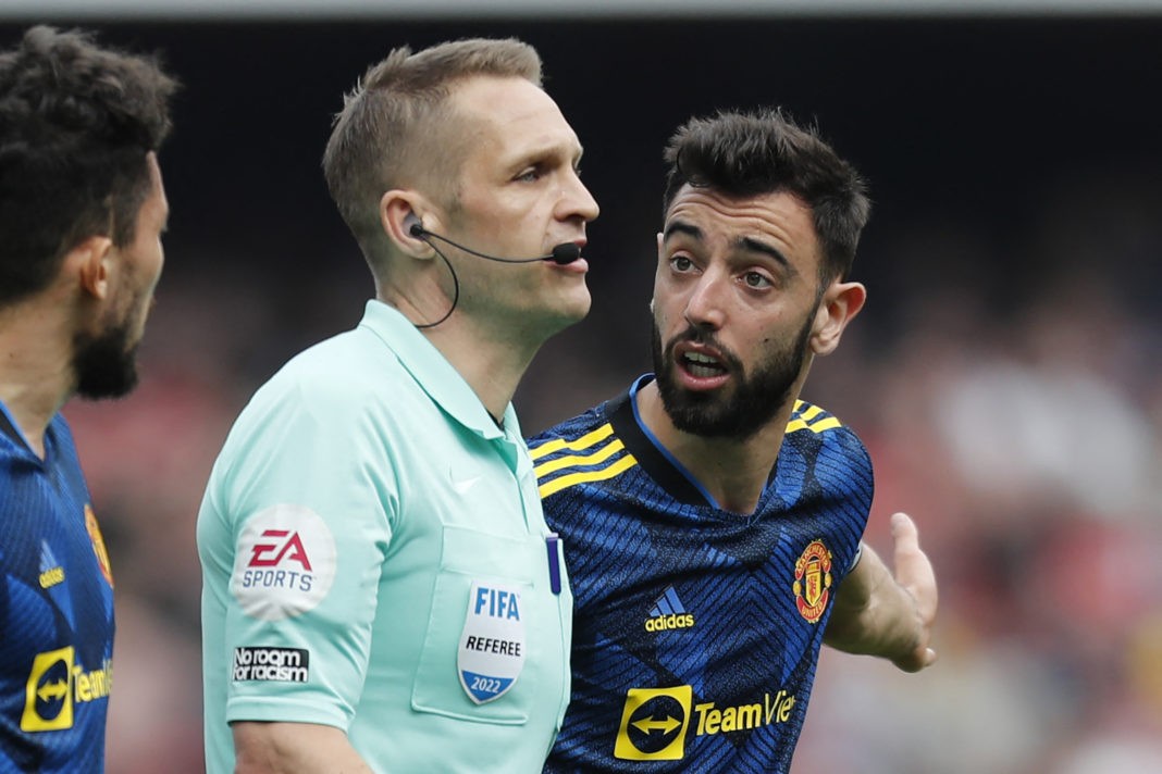 Manchester United's Portuguese midfielder Bruno Fernandes (R) appeals to English referee Craig Pawson (C) after he grants Arsenal a penalty during the English Premier League football match between Arsenal and Manchester United at the Emirates Stadium in London on April 23, 2022. (Photo by IAN KINGTON/IKIMAGES/AFP via Getty Images)
