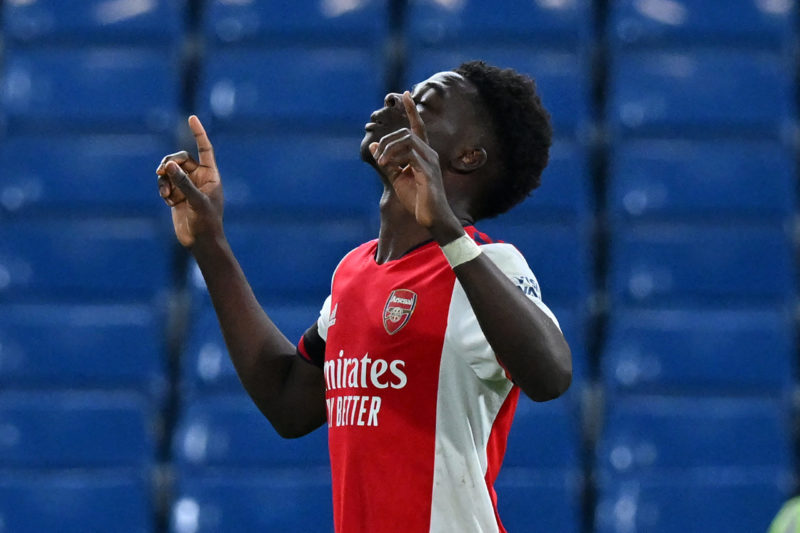 Arsenal's English midfielder Bukayo Saka celebrates after scoring their fourth goal from the penalty spot during the English Premier League football match between Chelsea and Arsenal at Stamford Bridge in London on April 20, 2022. - Arsenal won the game 4-2. (Photo by GLYN KIRK/AFP via Getty Images)