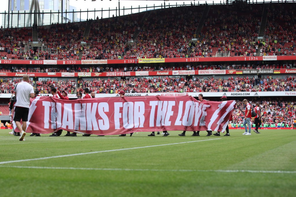 LONDON, ENGLAND: A banner reading 'Thanks for the love' is paraded in front of the fans after the Premier League match between Arsenal and Everton at Emirates Stadium on May 22, 2022. (Photo by Marc Atkins/Getty Images)
