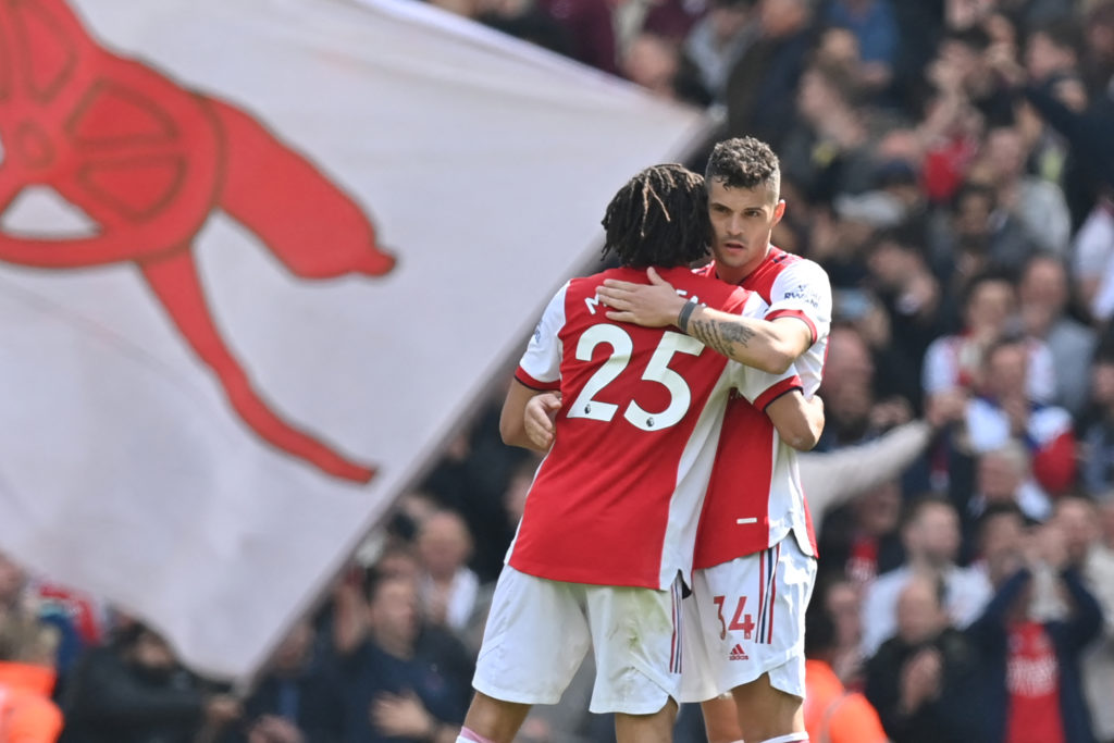 Arsenal's Swiss midfielder Granit Xhaka (R) embraces Arsenal's Egyptian midfielder Mohamed Elneny as they celebrate on the pitch after the English Premier League football match between Arsenal and Manchester United at the Emirates Stadium in London on April 23, 2022. (Photo by GLYN KIRK/AFP via Getty Images)