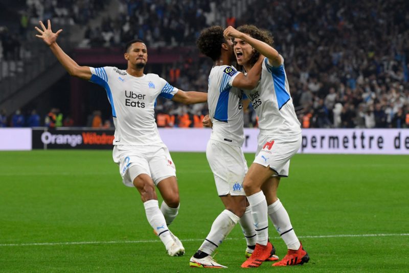 Marseille's French defender Boubacar Kamara (C) celebrates scoring his team's first goal with Marseille's French defender Matteo Guendouzi (R) and Marseille's French defender William Saliba (L) during the French L1 football match between Olympique de Marseille (OM) and FC Lorient at Stade Velodrome in Marseille, southern France on October 17, 2021. (Photo by Nicolas TUCAT / AFP)