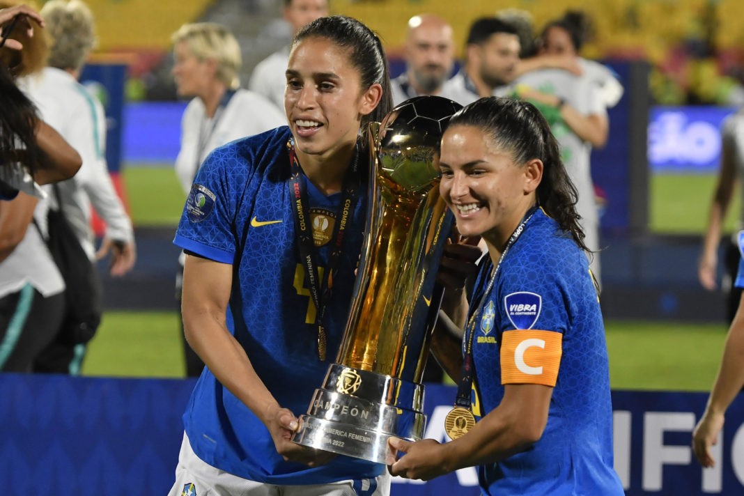 BUCARAMANGA, COLOMBIA - JULY 30: Rafaelle (L) of Brazil and Debinha (R) of Brazil celebrate with the trophy after winning the final match between Brazil and Colombia as part of Women's CONMEBOL Copa America 2022 at Estadio Alfonso Lopez on July 30, 2022 in Bucaramanga, Colombia. (Photo by Gabriel Aponte/Getty Images)