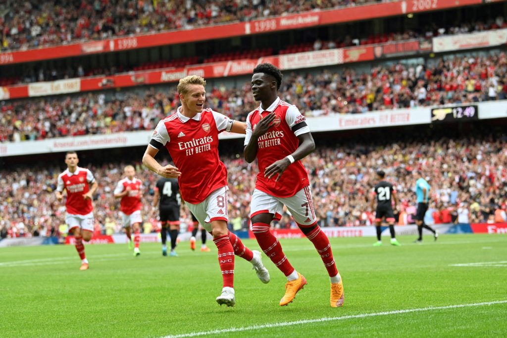 Arsenal's English midfielder Bukayo Saka (R) celebrates with Arsenal's Norwegian midfielder Martin Odegaard (L) after scoring his team's first goal during a club-friendly football match between Arsenal and Sevilla at the Emirates Stadium in London on July 30, 2022. (Photo by JUSTIN TALLIS/AFP via Getty Images)