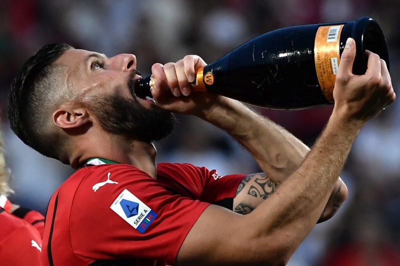 AC Milan's French forward Olivier Giroud drinks sparkling wine as he celebrates during the winner's trophy ceremony after AC Milan won the Italian Serie A football match between Sassuolo and AC Milan, securing the "Scudetto" championship on May 22, 2022 at the Mapei - Citta del Tricolore stadium in Sassuolo. (Photo by Filippo MONTEFORTE / AFP) (Photo by FILIPPO MONTEFORTE/AFP via Getty Images)