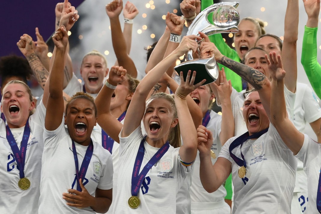 TOPSHOT - England's midfielder Leah Williamson (C) and England's defender Millie Bright (R) lift the trophy as England's players celebrate after their win in the UEFA Women's Euro 2022 final football match between England and Germany at the Wembley stadium, in London, on July 31, 2022. - England won a major women's tournament for the first time as Chloe Kelly's extra-time goal secured a 2-1 victory over Germany at a sold out Wembley on Sunday. (Photo by FRANCK FIFE / AFP)