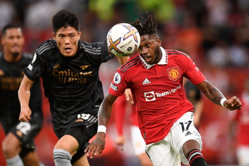 Manchester United's Brazilian midfielder Fred (R) vies with Arsenal's Japanese defender Takehiro Tomiyasu (L) during the English Premier League football match between Manchester United and Arsenal at Old Trafford in Manchester, north west England, on September 4, 2022. - Man Utd won the game 3-1. (Photo by OLI SCARFF/AFP via Getty Images)