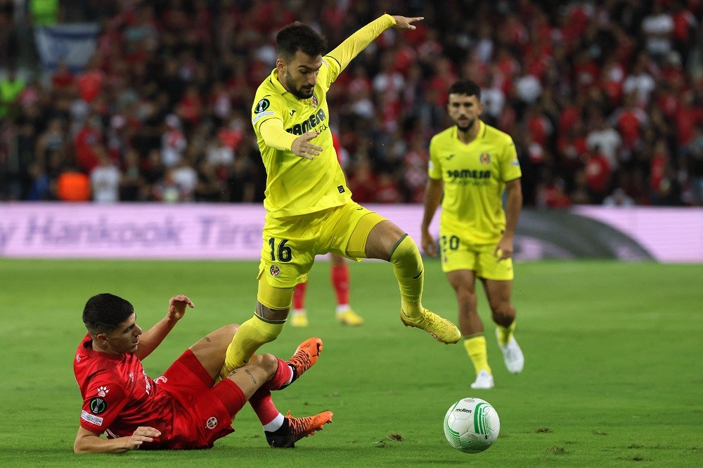 Villarreal's Spanish midfielder Alex Baena (C) is tackled by Hapoel Beer-Sheva's Israeli defender Or Dadia during the UEFA Europa Conference League football match between Israel's Hapoel Beer-Sheva and Spain's Villarreal at the Turner stadium in the city of Beer Sheva on September 15, 2022. (Photo by JACK GUEZ/AFP via Getty Images)
