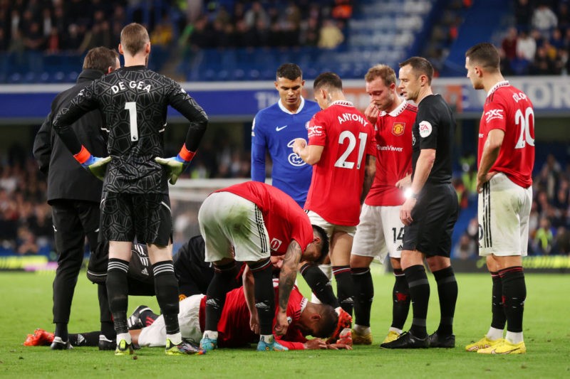 LONDON, ENGLAND - OCTOBER 22: Raphael Varane of Manchester United receives medical attention during the Premier League match between Chelsea FC and Manchester United at Stamford Bridge on October 22, 2022 in London, England. (Photo by Alex Pantling/Getty Images)