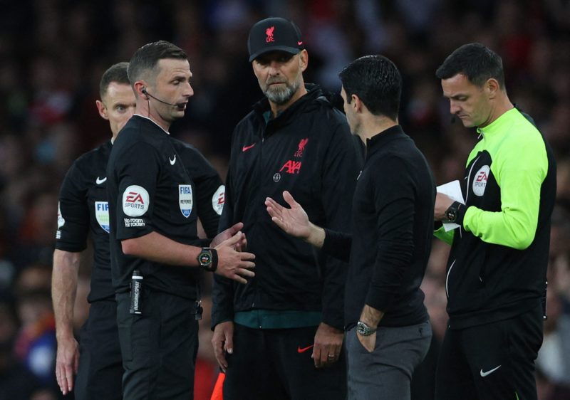 Referee Michael Oliver (2L) speaks to Liverpool's German manager Jurgen Klopp and Arsenal's Spanish manager Mikel Arteta during the English Premier League football match between Arsenal and Liverpool at the Emirates Stadium in London on October 9, 2022. (Photo by ADRIAN DENNIS/AFP via Getty Images)