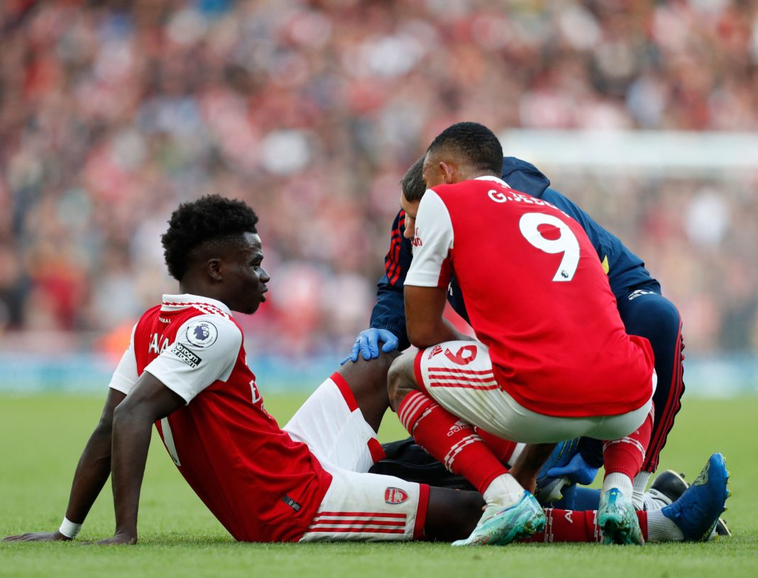 Arsenal's English midfielder Bukayo Saka speaks to Arsenal's Brazilian striker Gabriel Jesus (R) as he is treated by a member of the medical staff after picking up an injury during the English Premier League football match between Arsenal and Nottingham Forest at the Emirates Stadium in London on October 30, 2022. (Photo by IAN KINGTON/AFP via Getty Images)