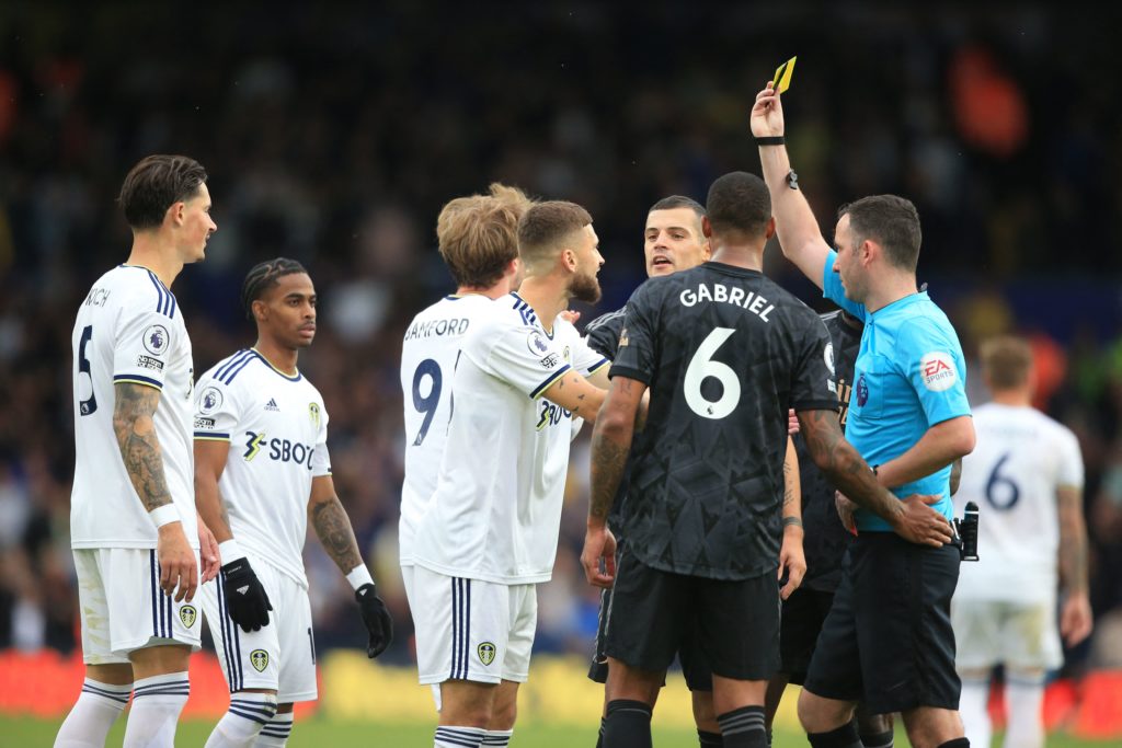 English referee Chris Kavanagh (R) shows a yellow card to Arsenal's Brazilian defender Gabriel Magalhaes (C) having earlier shown his a red card during the English Premier League football match between Leeds United and Arsenal at Elland Road in Leeds, northern England on October 16, 2022. - RESTRICTED TO EDITORIAL USE. No use with unauthorized audio, video, data, fixture lists, club/league logos or 'live' services. Online in-match use limited to 120 images. An additional 40 images may be used in extra time. No video emulation. Social media in-match use limited to 120 images. An additional 40 images may be used in extra time. No use in betting publications, games or single club/league/player publications. (Photo by Lindsey Parnaby / AFP) / RESTRICTED TO EDITORIAL USE. No use with unauthorized audio, video, data, fixture lists, club/league logos or 'live' services. Online in-match use limited to 120 images. An additional 40 images may be used in extra time. No video emulation. Social media in-match use limited to 120 images. An additional 40 images may be used in extra time. No use in betting publications, games or single club/league/player publications. / RESTRICTED TO EDITORIAL USE. No use with unauthorized audio, video, data, fixture lists, club/league logos or 'live' services. Online in-match use limited to 120 images. An additional 40 images may be used in extra time. No video emulation. Social media in-match use limited to 120 images. An additional 40 images may be used in extra time. No use in betting publications, games or single club/league/player publications. (Photo by LINDSEY PARNABY/AFP via Getty Images)