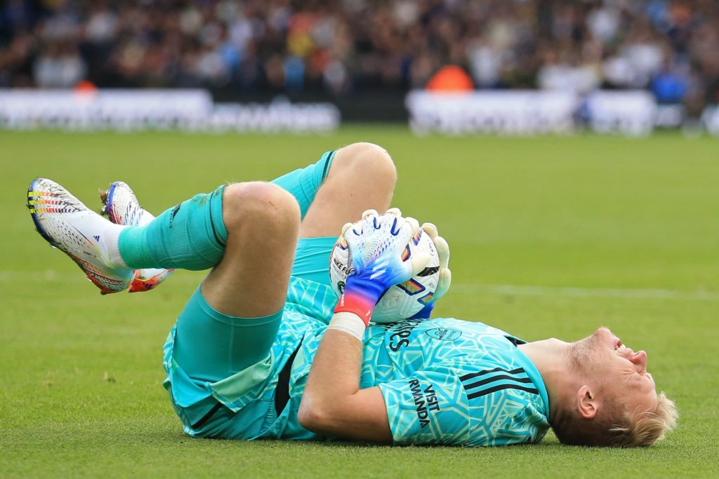 Arsenal's English goalkeeper Aaron Ramsdale reacts after suffering a knock during the English Premier League football match between Leeds United and Arsenal at Elland Road in Leeds, northern England on October 16, 2022 (Photo by LINDSEY PARNABY/AFP via Getty Images)