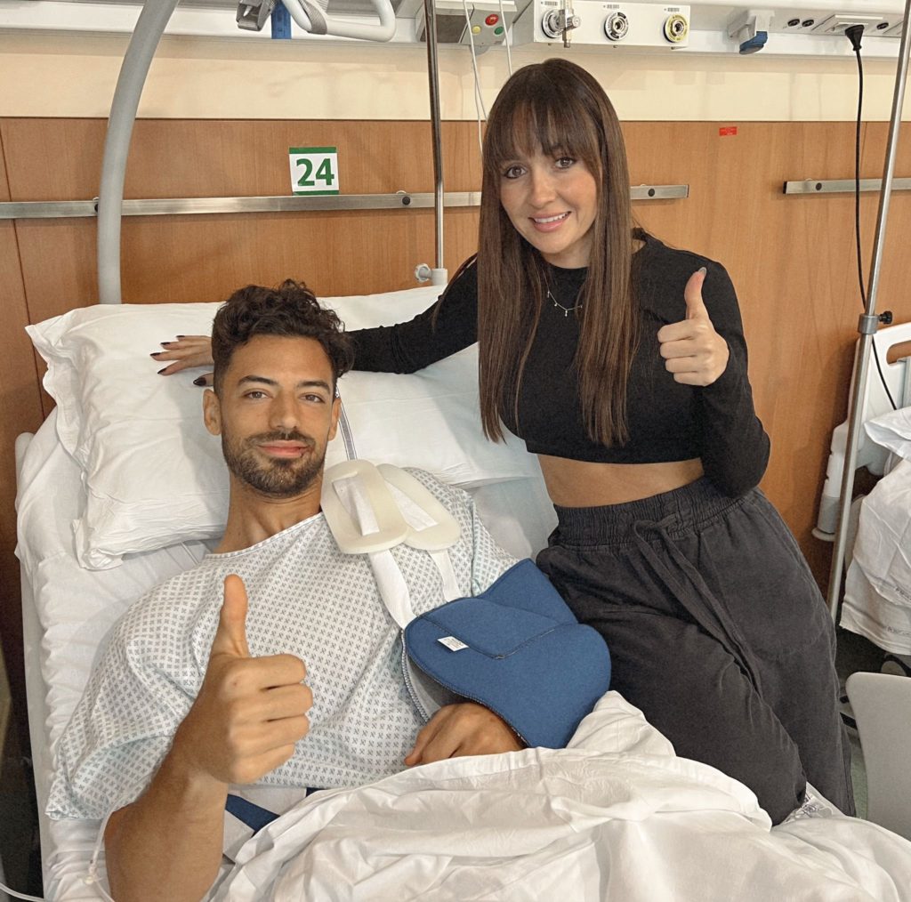 Pablo Mari gives a thumbs up from his hospital bed as his wife stands beside him doing the same