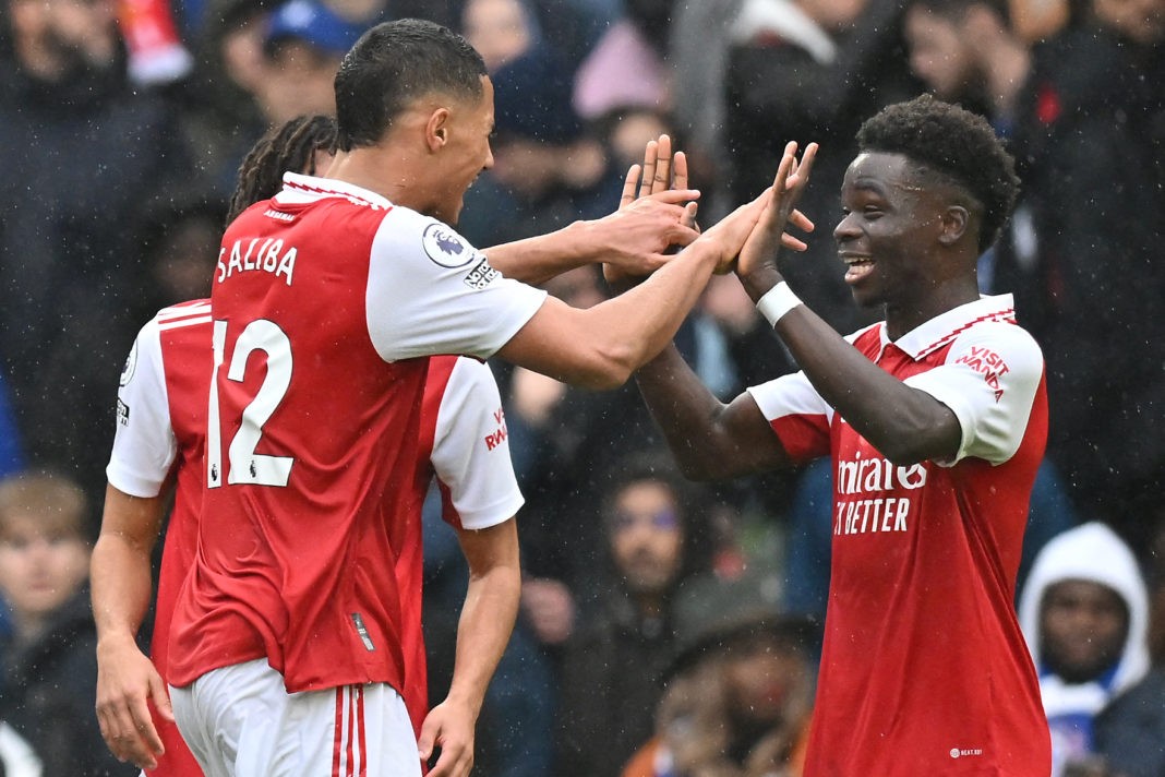 Arsenal's French defender William Saliba (L) celebrates with Arsenal's English midfielder Bukayo Saka (R) after the final whistle of the English Premier League football match between Chelsea and Arsenal at Stamford Bridge in London on November 6, 2022.(Photo by GLYN KIRK/AFP via Getty Images)