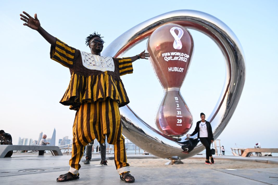 A fan of Ghana's national football team poses with the FIFA World Cup countdown clock in Doha on November 7, 2022, ahead of the Qatar 2022 FIFA World Cup football tournament. (Photo by Kirill KUDRYAVTSEV / AFP) (Photo by KIRILL KUDRYAVTSEV/AFP via Getty Images)