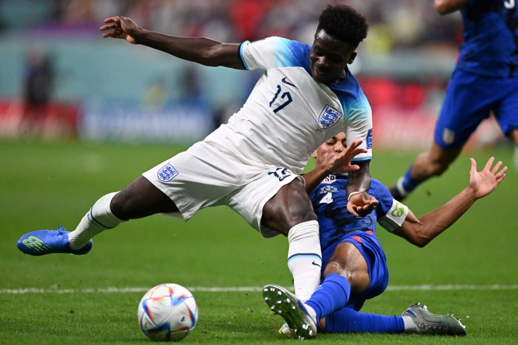 England's forward #17 Bukayo Saka (L) and USA's midfielder #04 Tyler Adams fight for the ball during the Qatar 2022 World Cup Group B football match between England and USA at the Al-Bayt Stadium in Al Khor, north of Doha on November 25, 2022. (Photo by KIRILL KUDRYAVTSEV/AFP via Getty Images)