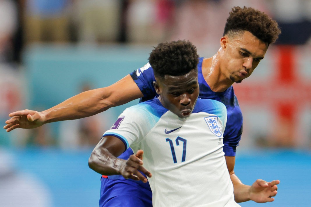 England's forward #17 Bukayo Saka (L) fights for the ball with USA's defender #05 Antonee Robinson during the Qatar 2022 World Cup Group B football match between England and USA at the Al-Bayt Stadium in Al Khor, north of Doha on November 25, 2022. (Photo by ODD ANDERSEN/AFP via Getty Images)