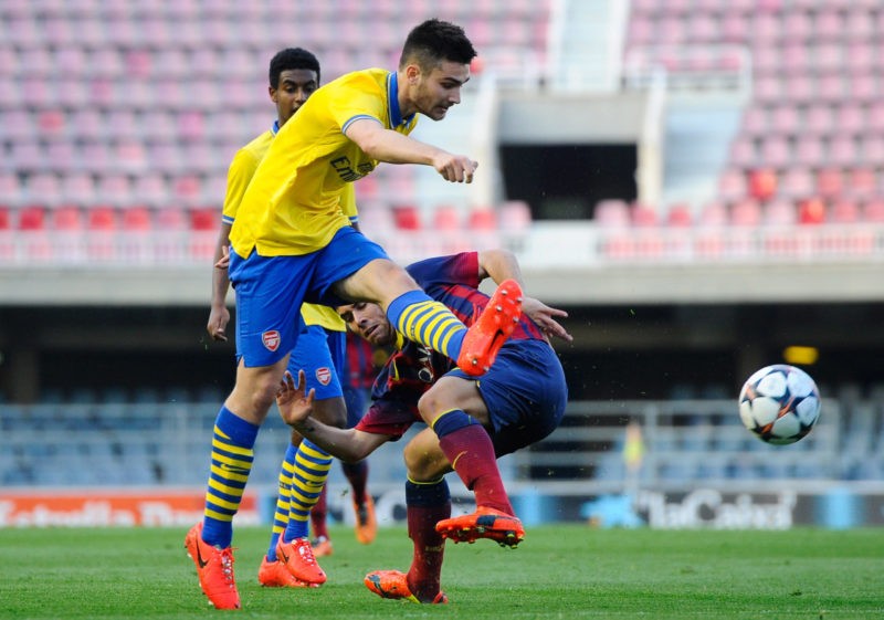 BARCELONA, SPAIN - MARCH 18:  Jon Toral of Arsenal shoots towards goal under a challenge by Juanma during the UEFA Youth League Quarter FInal match between FC Barcelona U19 and Arsenal U19 at Mini Estadi on March 18, 2014 in Barcelona, Spain.  (Photo by David Ramos/Getty Images)