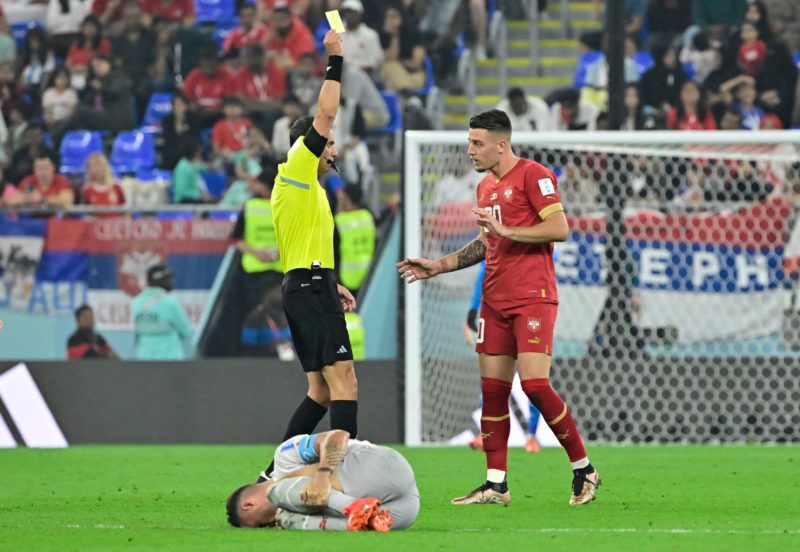 Argentinian referee Fernando Rapallini shows a yellow card to Serbia's midfielder #20 Sergej Milinkovic-Savic for a foul over Switzerland's midfielder #10 Granit Xhaka during the Qatar 2022 World Cup Group G football match between Serbia and Switzerland at Stadium 974 in Doha on December 2, 2022. (Photo by JAVIER SORIANO/AFP via Getty Images)
