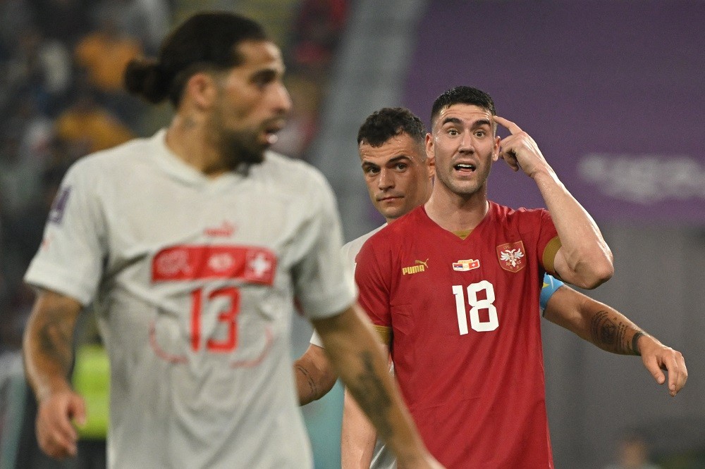 Serbian forward Dusan Vlahovic gestures next to Switzerland's Granit Xhaka during the Qatar 2022 World Cup Group G football match between Serbia and Switzerland at Stadium 974 in Doha on December 2, 2022. (Photo by ANDREJ ISAKOVIC/AFP via Getty Images)
