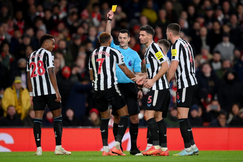 LONDON, ENGLAND - JANUARY 03: Referee Andy Madley shows a yellow card to Joelinton of Newcastle United during the Premier League match between Arsenal FC and Newcastle United at Emirates Stadium on January 03, 2023 in London, England. (Photo by Justin Setterfield/Getty Images)