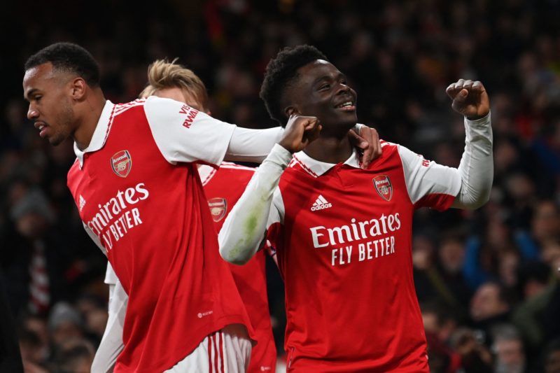 Arsenal's English midfielder Bukayo Saka (R) celebrates after scoring their second goal during the English Premier League football match between Arsenal and Manchester United at the Emirates Stadium in London on January 22, 2023. (Photo by GLYN KIRK/AFP via Getty Images)
