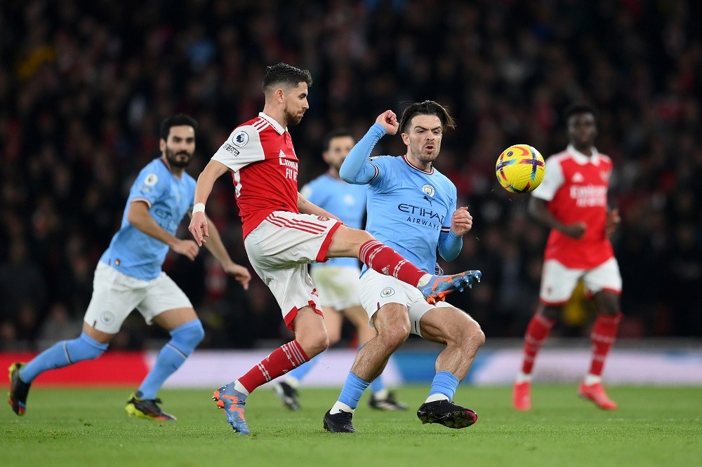 LONDON, ENGLAND: Jorginho of Arsenal passes the ball whilst under pressure from Jack Grealish of Manchester City during the Premier League match between Arsenal FC and Manchester City at Emirates Stadium on February 15, 2023. (Photo by Shaun Botterill/Getty Images)