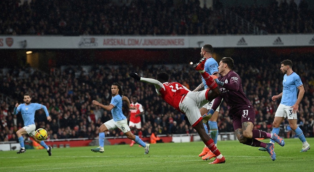 Arsenal's English striker Eddie Nketiah (L) collides with Manchester City's Brazilian goalkeeper Ederson as they fight for the ball during the English Premier League football match between Arsenal and Manchester City at the Emirates Stadium in London on February 15, 2023. (Photo by GLYN KIRK/AFP via Getty Images)