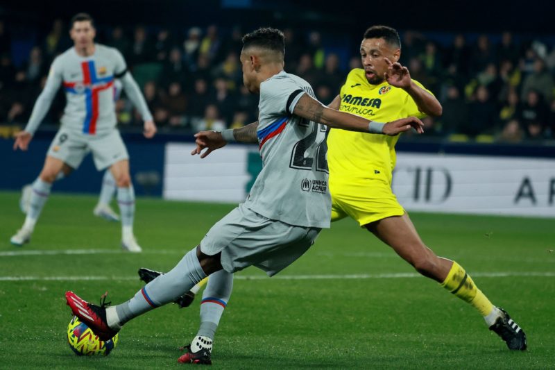 Barcelona's Brazilian forward Raphinha (L) vies with Villarreal's French midfielder Francis Coquelin during the Spanish League football match between Villarreal CF and FC Barcelona at La Ceramica stadium in Vila-real on February 12, 2023. (Photo by JOSE JORDAN / AFP) (Photo by JOSE JORDAN/AFP via Getty Images)